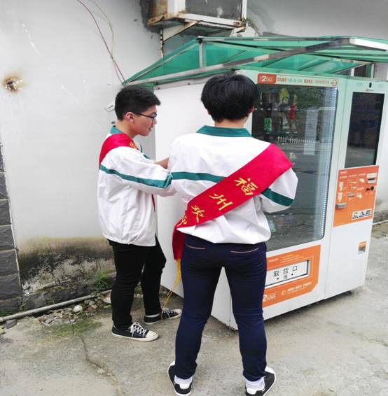 系部志愿者清理校内路边自动贩卖机上的小广告 系部志愿者清理校内路边自动贩卖机上的小广告